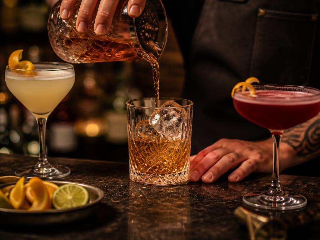 Craft cocktails poured at a dimly lit bar
